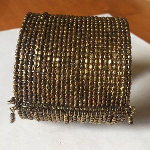 Golden metal beaded cuff bracelet.